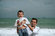 © alexkoral - happy father with child boy son playing on the beach by the sea in summer on vacation