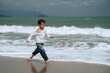 © alexkoral - happy child boy running along the beach by sea in summer on vacation