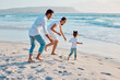 © peopleimages.com - Happy family, beach or toddler playing with parents on ocean coast for summer vacation, bonding or holiday. Mom, dad and little girl running with playful guardians for fun weekend or childhood by sea