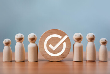 Poster - Teamwork and Business Success. A group of happy wooden figures surrounds a wooden disc with a checkmark, representing teamwork, success, quality assurance, leadership, and positive evaluation.