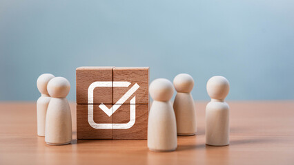 Poster - Teamwork and Business Success. A group of happy wooden figures surrounds a wooden disc with a checkmark, representing teamwork, success, quality assurance, leadership, and positive evaluation.