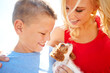 © peopleimages.com - Outdoor, mother and child with dog after adoption, puppy care and bonding together with happiness. Family, woman and boy with pet animal for companion, share moment and connection by sunshine