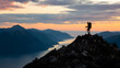 © abdulmoizjaangda - Person standing atop a mountain peak at sunset, overlooking serene water below