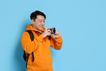 Sticker - Traveller taking photo on light blue background. Space for text