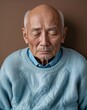 © sevenSkies - Elderly Asian man sleepy bald head light blue sweater on brown background