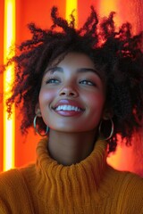 Wall Mural - Smiling young woman with curly hair in warm turtleneck top against vibrant neon backdrop