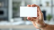 © RonaldBin - A hand holding a blank white card, close-up focus, with a blurred professional background, creating a clean and minimalistic look.