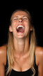 © AndyGordon - a woman laughing with her mouth wide open, against a black background.