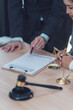 © Kritdanai - Legal Counsel: A lawyer meticulously reviews a legal document with a client,  representing the importance of detail and precision in legal matters, symbolized by the gavel and scales of justice.