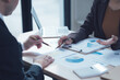 © Kritdanai - Strategic Planning Meeting: A businessman and businesswoman analyze financial data, charts and graphs, discussing strategies and collaborating for business growth.