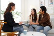 © supAVADEE BUTRADEE - female Asian psychiatrist made an appointment with a family to receive counseling. She sat down to give advice to an Asian couple who were having problems with disappointment and anxiety about work