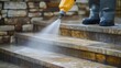 © Sawyer0 - A professional cleaning service uses a high-pressure water jet to thoroughly wash exterior stone stairs, removing dirt and grime for a spotless finish.
