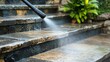 © Sawyer0 - A professional cleaning service uses a high-pressure water jet to thoroughly wash exterior stone stairs, removing dirt and grime for a spotless finish.
