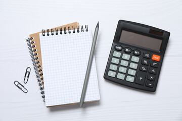 top view photo of office accessories calculator, notebook and pencil on white background with empty 