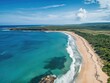 © Rapit - Aerial view of a scenic beach with turquoise water and green coastal vegetation