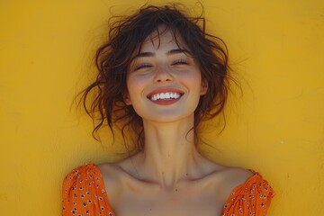 Wall Mural - Smiling woman in vibrant orange dress against yellow wall enjoys a sunny day