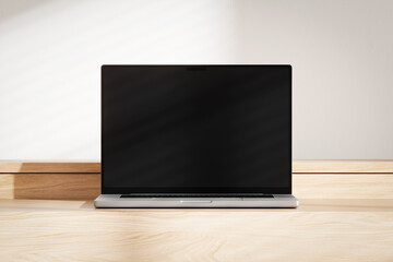 Wall Mural - opened laptop with blank black screen on the wooden desk