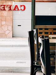 Poster - Empty chairs stand inside a cafe with the shutters down, symbolizing the impact of lockdown on small businesses