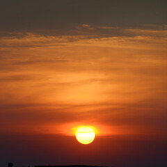 Wall Mural - Bright sun against the background of red clouds.