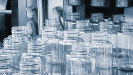 Poster - Bottle. Industrial production of plastic pet bottles. Factory line for manufacturing polyethylene bottles. Transparent food packaging.