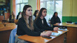 © Довидович Михаил - High school students actively engaged in a classroom lesson, listening attentively to their teacher
