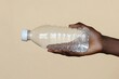 © masud - Hand Holding a Clear Plastic Water Bottle