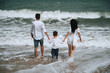 © alexkoral - back of family parents with a child boy son on the beach in the sea on summer vacation
