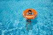 © alexkoral - child boy in an inflatable circle learns to swim in swimming pool at a hotel on summer vacation