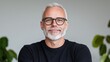 © Giman - Smiling mature man, indoor portrait, neutral background, plants blurred, for business profile