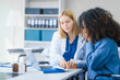© Phushutter - A young African American patient consults with a young Russian medical doctor about her immune system and vitamin intake. They discuss patient medical history,  vitamin and pill bottles on the desk.