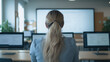 © CreativeIMGIdeas - Student in Computer Lab: A young woman with long blonde hair sits facing a projector screen in a computer lab, her back to the camera.  She's surrounded by computers.