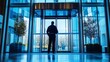 © HPMP Studio - Back view of security guard standing watch against a high-tech glass door