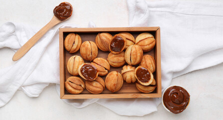 Canvas Print - Wooden box of sweet walnut shaped cookies with boiled condensed milk on white background