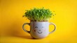 © kavalin - A cheerful gray mug with a smiling face, adorned with vibrant green cress, exudes joy and optimism against a bright yellow background.