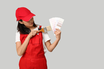 Wall Mural - female asian painter with paint color palettes and brush on grey background