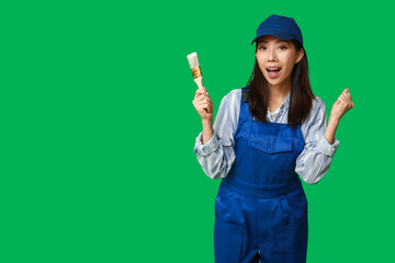 Wall Mural - female asian surprised painter with brush on green background