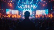 © Nana - Silhouette of a man in a large concert crowd facing a bright stage
