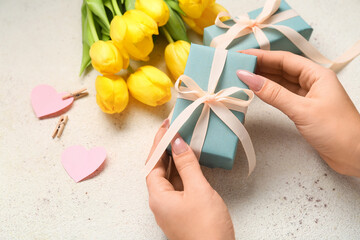 Wall Mural - Female hands with amazing gift box on light background