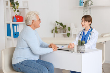 Poster - Female doctor working with mature man at table in clinic