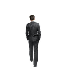 Poster - A man in a formal suit walking away with hands in pockets, isolated on a white background. Professional, business, or corporate concept