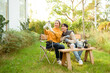 © tonefotografia - Two Friends Enjoying a Cozy Outdoor Moment While Taking a Selfie in a Sunny Garden