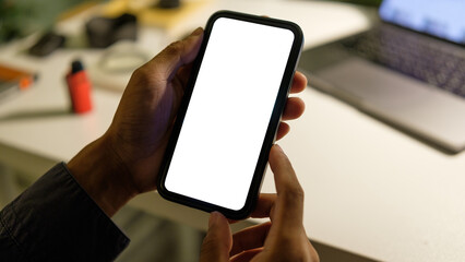 Wall Mural - close up of hand holding a smartphone with blank white screen for app or website mockup designs.