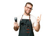© luismolinero - Barber man in an apron over isolated chroma key background showing and lifting a finger in sign of the best