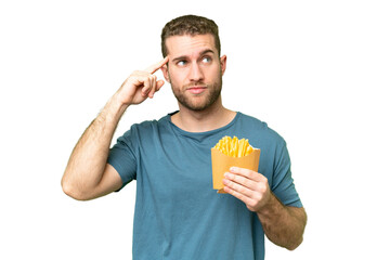 Wall Mural - Young handsome blonde man holding fried chips over isolated chroma key background having doubts and thinking