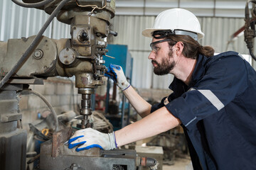 Poster - Professional male engineer maintenance lathe machine in industry factory. Engineer repairing lathe machine with safety uniform, goggles and helmet