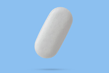 White medicine pill tablet float on blue background