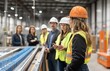 © Asih - Female engineer in hard hat leads a team in a factory.