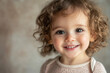 © Ann - Smiling child with curly hair shows joy and innocence in a warm indoor setting