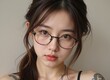 © Lydia - close-up portrait of a cute asian girl with freckles and round glasses, looking embarrassed as she gazes directly at the viewer