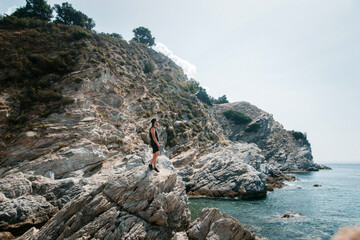 Wall Mural - Person on Rocky Cliff Overlooking Ocean